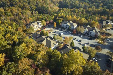 Sonbahar mevsiminde Güney Carolina banliyölerinde sarı ağaçlar arasındaki yeni apartman dairelerinin hava manzarası. Amerikan banliyölerinde gayrimenkul geliştirme.