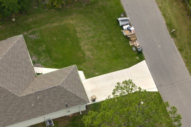 Tipik modern Amerikan özel evinin çatısı asfalt kiremitlerle ve bahçedeki yeşil çimlerle kaplı..