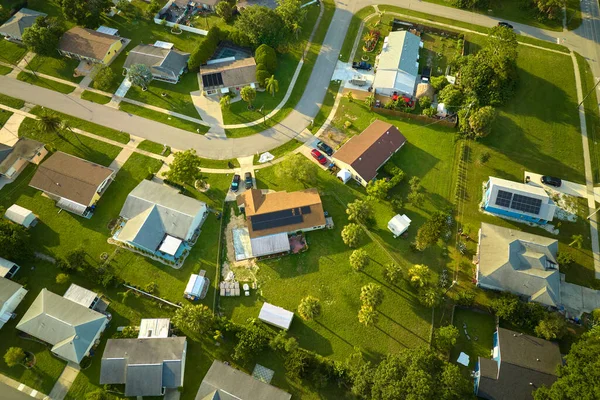 Aerial view of small town America suburban landscape with private homes between green palm trees in Florida quiet residential area.