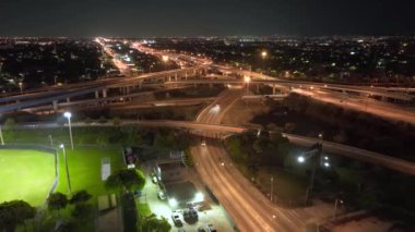 Miami, Florida 'daki hızlı sürüş araçlarıyla gece Amerikan otoyol kavşağının hava görüntüsü. ABD ulaşım altyapısının üstünden görüntüle.