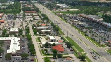 North Port, Florida 'da alışveriş merkezleri ve araba sürücüleri olan çok şeritli Amerikan yolu. ABD 'nin perakende ve ulaştırma altyapısının üzerinden görüntüle.