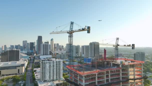 アメリカの都市部に住宅開発の新しい建設現場 フロリダ州マイアミでクレーンを持ち上げる工業タワー アメリカにおける住宅成長の概念 — ストック動画
