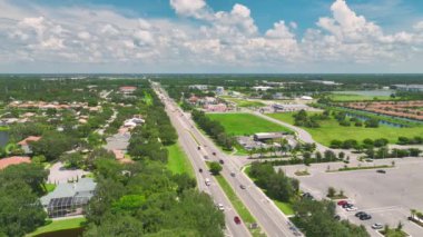 North Port, Florida 'daki American Geniş Yolu ve alışveriş merkezi plazasından görüntü. Sürücü arabalı şehir trafiği. ABD ulaştırma altyapı kavramı.