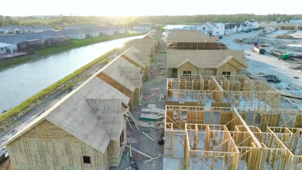 木製の屋根の梁を建設中の安価な家の未完成のフレームの上からの眺め 米国郊外における住宅開発 米国の不動産市場 — ストック動画