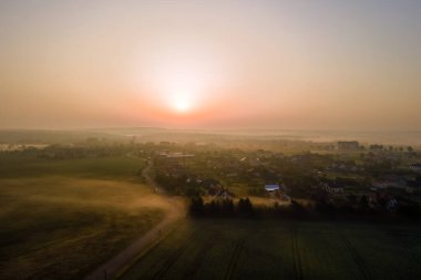 Yeşil ekili tarlaların, büyüyen ekinlerin ve parlak yaz akşamlarında uzak köy evlerinin hava manzarası..