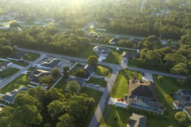 Florida 'nın sakin kırsal kesimindeki yeşil palmiye ağaçları arasındaki banliyö özel evlerinin hava manzarası.