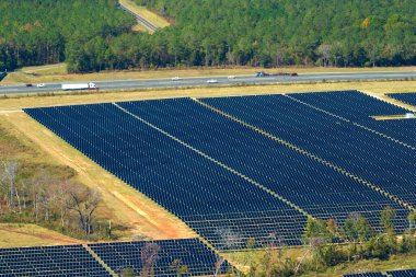 Temiz elektrik enerjisi üretmek için birçok sıra güneş fotovoltaik paneli bulunan sürdürülebilir büyük elektrik santralinin havadan görünüşü. Sıfır emisyon kavramı ile yenilenebilir elektrik.
