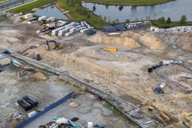 Hazırlanmış zeminde inşaatın başlaması. Amerikan kırsal bölgesinde dağınık ekipmanlı büyük bir inşaat alanı. ABD banliyölerinde konut geliştirme. ABD 'de emlak piyasası.