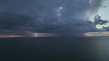 Şiddetli yağış mevsiminde yaz akşamları deniz suyu üzerinde fırtınalı gökyüzünde kara hava bulutları oluşur..