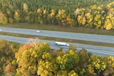 Yoğun Amerikan otoyolunun üzerinden hızlı hareket eden kamyon ve arabaların görüntüsü. Eyaletler arası ulaşım kavramı.