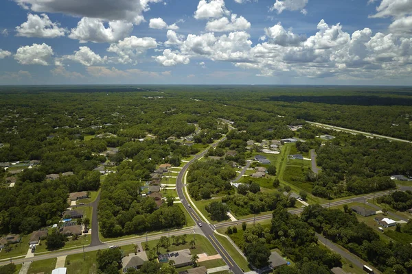 stock image Aerial view of street traffic with driving cars in small town. American suburban landscape with private homes between green palm trees in Florida quiet residential area.