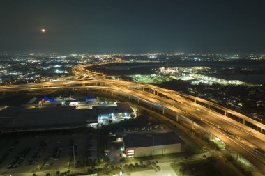 Tampa, Florida 'da gece vakti hızlı hareket eden araçlar ve kamyonlarla Amerikan otobanının kavşağından bir görüntü. ABD ulaştırma altyapı kavramı.