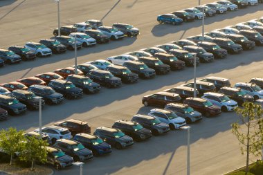 Satıcıların açık hava otoparkından bir sürü yeni araba satışa sunuluyor. Amerikan otomotiv endüstrisinin gelişimi kavramı.