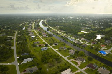 Florida 'nın sakin yerleşim bölgesinde yeşil palmiye ağaçları arasında özel evleri olan küçük bir Amerikan banliyö manzarası..