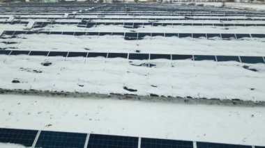 Kar, temiz elektrik enerjisi üretmek için birçok sıra güneş fotovoltaik paneliyle sürdürülebilir elektrik santralini kapladı. Kışın yenilenebilir elektriğin düşük etkisi.