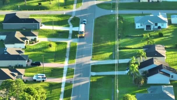 在空中观看美国黄色校车在郊区的街道上开车送孩子上学的情景 美国的公共交通 — 图库视频影像