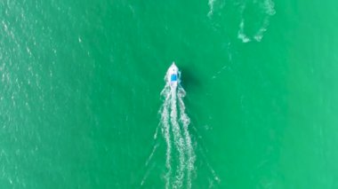 Dalgalanma yüzeyi ile deniz dalgaları üzerinde hızla giden motorlu teknenin hava görüntüsü. Yelkenli Florida 'da okyanusta hareket ediyor..