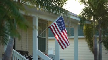 Florida özel evinin ön bahçesinde Amerikan bayrağı dalgalanıyor. Demokrasinin sembolü olarak gösterilen Amerikan yıldızlarının ve çizgilerinin havadan görünüşü.