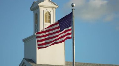 Mavi gökyüzüne karşı rüzgarda dalgalanan Amerikan ulusal bayrağı. ABD 'li yıldızlar ve çizgiler demokrasinin sembolü olarak gösterildi.