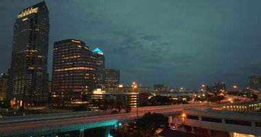 Florida, ABD 'nin Tampa şehrinin şehir merkezindeki gece şehir manzarası. Sürücü arabaları ve modern Amerikan megapolis 'indeki parlak gökdelen binalarıyla gökdelenler..