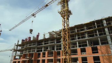 Vinç kaldırma kulesi ve inşaat halindeki monolitik çerçeveli yüksek konutlu bina. Gayrimenkul geliştirme.