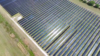 Temiz elektrik enerjisi üretmek için birçok sıra güneş paneli bulunan fotovoltaik enerji santralinin üzerinden görüntülenebilir. Hava kirliliği olmayan yenilenebilir elektrik kavramı.