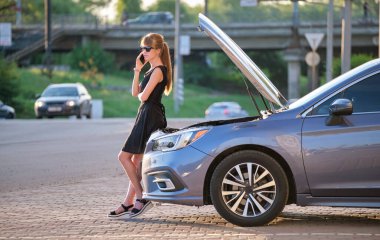 Kaputu açık bir şekilde arabasının yanında duran çaresiz kadın yardım için yol servisini arıyor. Genç bayan sürücünün aracıyla ilgili sorunları var.