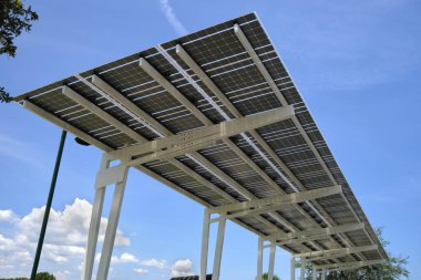 Solar panels installed over parking lot canopy shade for parked cars for effective generation of clean energy.