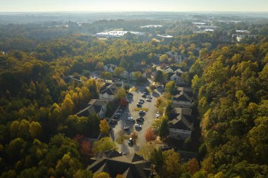 Güney Carolina 'nın banliyö bölgesindeki sarı sonbahar ağaçları arasındaki apartman dairelerinin üstünden bak. Amerikan banliyölerinde emlak gelişimine örnek olarak Amerikan evleri.