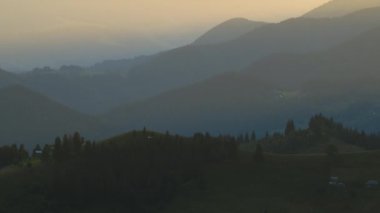Yamaçta eski çoban evleri olan vahşi dağ ormanlarında gün batımı manzarası inanılmazdır. Güzel doğa manzarası.