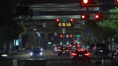 Trafik ışıkları ve gece hareket halindeki arabalarla dolu Amerikan kavşağı. ABD 'de ulaşım sistemi