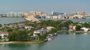 Florida, ABD 'deki Sarasota şehrindeki yeşil palmiye ağaçları arasında pahalı rıhtım evleri. Ufuktaki şehir merkezindeki yüksek katlı ofis binaları. Birinci sınıf konut geliştirme.