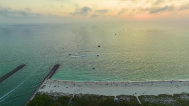 フロリダ州ヴェネツィア近くのノカムビーチで北と南ジェティ 海の波に浮かぶ白いヨットと海岸の空中ビュー 海面でのモーターボートレクリエーション — ストック動画