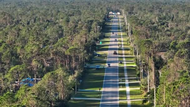 在美国佛罗里达州的一个小镇上 乡村道路上开着交通车辆 安静住宅区绿树与郊区街道之间的私人住宅 — 图库视频影像