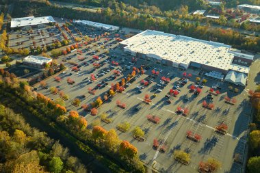 Rgocery mağazasının önündeki büyük otoparkın havadan görüntüsü. Bir sürü renkli araba park edilmiş. Araç mekanları ve yönleri için çizgiler ve işaretlerle süpermerkez alışveriş merkezindeki otopark..