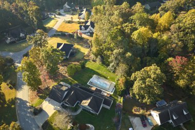 Sonbahar mevsiminde Güney Carolina banliyölerindeki sarı ağaçlar arasındaki yeni aile evlerinin havadan görünüşü. Amerikan banliyölerinde gayrimenkul geliştirme.