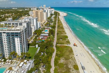 Sıcak Florida güneşinde dinlenen turistlerle birlikte güney sahilinin kumlu yüzeyi. Yüksek lüks otelleri ve apartmanları olan Miami Beach City. Güney Amerika 'da turizm altyapısı.