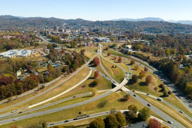 American freeway intersection in Asheville, North Carolina with fast driving cars and trucks in autumnal season. View from above of USA transportation infrastructure.