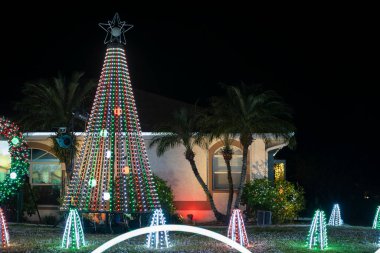 Florida aile evinin ön bahçesinde parlak ışıklandırılmış noel süslemeleri. Kış tatili için dışarıda dekor.