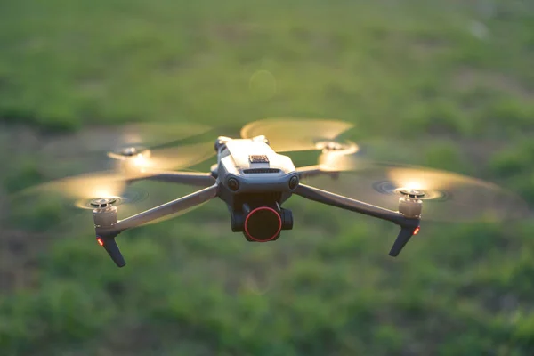 Drone quadcopter with digital camera and fast rotating propellers flying taking video and pictures.