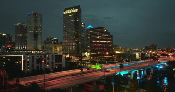 フロリダ州タンパ市のダウンタウンのハイウェイ交通の空中視界 現代アメリカのミッドタウンに明るく照らされた高層ビル — ストック動画