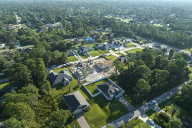 Florida kırsal kesiminde ahşap iskeleti olan bitmemiş bir banliyö evinin çatı inşaatında çalışan profesyonel müteahhitler. Amerika 'da konut geliştirme kavramı.