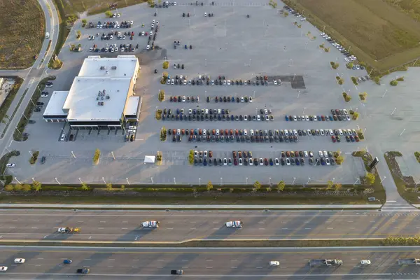 stock image View from above of dealers outdoor parking lot with many brand new cars in stock for sale on highway side. Concept of development of american automotive industry.