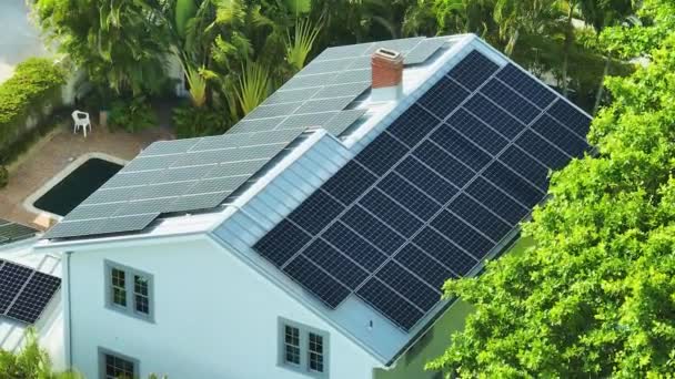 きれいな生態系の電気エネルギーを生成するための青い太陽光発電パネルの行を持つ新しい高価なアメリカの建物の屋根の空中ビュー 排出ゼロをコンセプトとした再生可能エネルギー — ストック動画