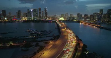 Trafik sıkışıklığı Amerikan şehrinin şehir merkezinde geceleyin Miami, Florida 'da geniş bir otoyol köprüsünde meydana gelen trafik kazasından kaynaklanıyor. Kentsel ulaşım altyapısı üzerine gökdelen binaları