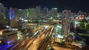 Miami City, Florida 'da gece hızlı giden araba ve kamyonlarla Amerikan otoyolu kavşağının hava görüntüsü. ABD ulaşım altyapısının üstünden görüntüle.