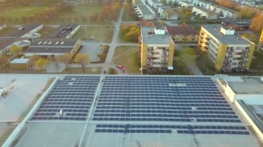 Aerial view of blue photovoltaic solar panels mounted on shopping mall building roof for producing green ecological electricity. Production of sustainable energy concept.