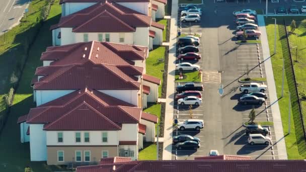 フロリダ州の住宅街にあるアメリカのアパートの建物の駐車場に駐車された自動車の空中ビュー 米国の郊外での住宅開発の例としての新しい家族のコンドーム — ストック動画
