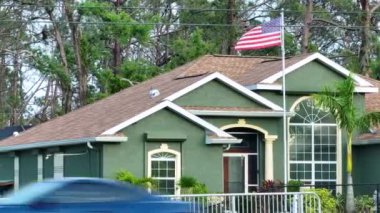 Florida özel evinin ön bahçesinde Amerikan bayrağı dalgalanıyor. Demokrasinin sembolü olarak gösterilen Amerikan yıldızlarının ve çizgilerinin havadan görünüşü.
