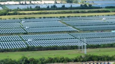 Temiz elektrik enerjisi üretmek için sıra sıra güneş fotovoltaik panelleri olan sürdürülebilir büyük elektrik santralinin havadan görünüşü. Sıfır emisyonlu yenilenebilir elektrik kavramı.